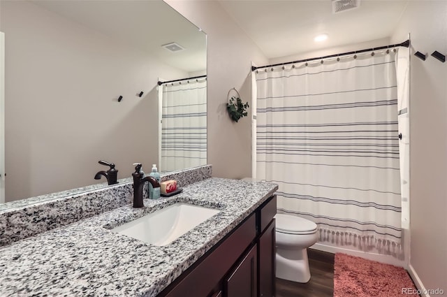 bathroom with visible vents, toilet, wood finished floors, shower / bath combination with curtain, and vanity