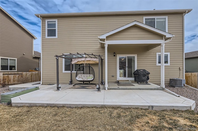 back of property with fence, a pergola, and a patio area