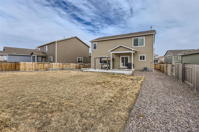 rear view of property featuring a fenced backyard, a yard, cooling unit, and a patio