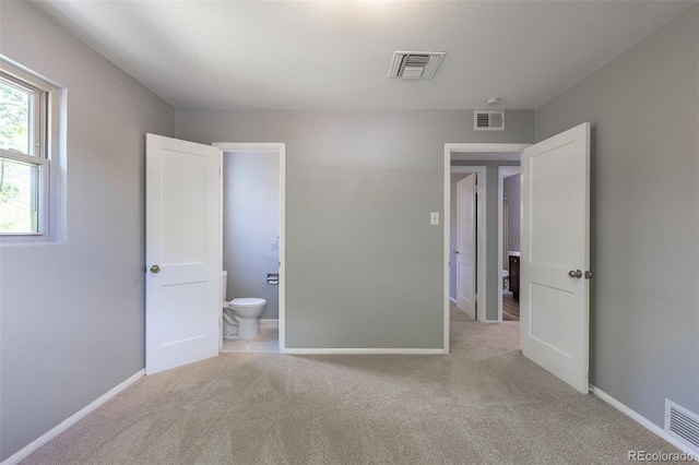1099 Wheeling St, Aurora, CO 80011 - unfurnished bedroom featuring light carpet and ensuite bath