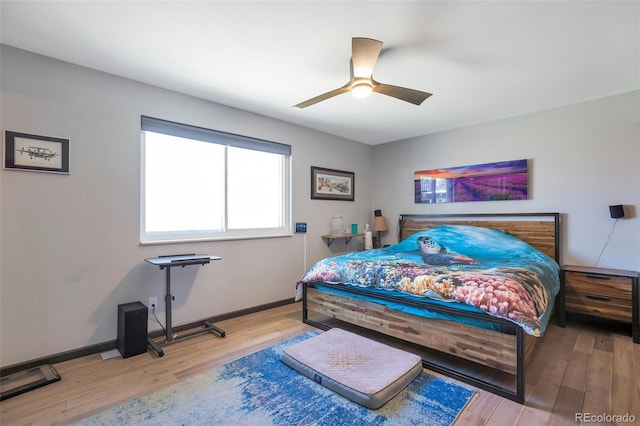 bedroom with a ceiling fan, baseboards, and wood finished floors