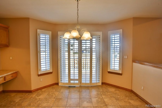 unfurnished dining area with a healthy amount of sunlight, light tile patterned floors, and an inviting chandelier