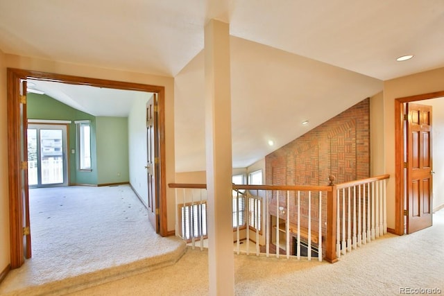 corridor featuring light colored carpet and lofted ceiling