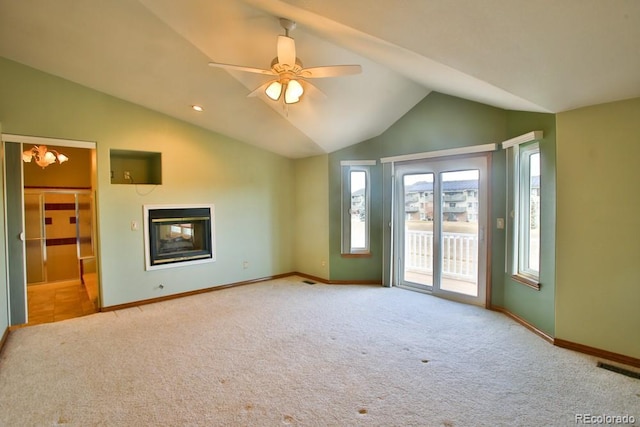 unfurnished living room featuring ceiling fan, a multi sided fireplace, vaulted ceiling, and light carpet