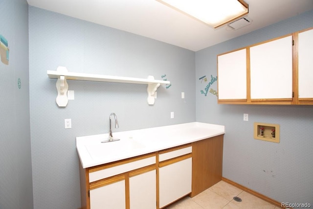 laundry area featuring cabinets, washer hookup, and light tile patterned floors