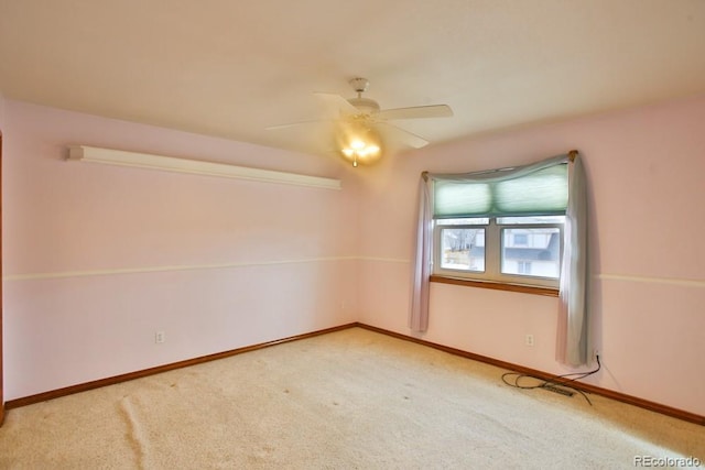 carpeted spare room featuring ceiling fan