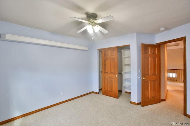 unfurnished bedroom featuring light colored carpet, a closet, and ceiling fan