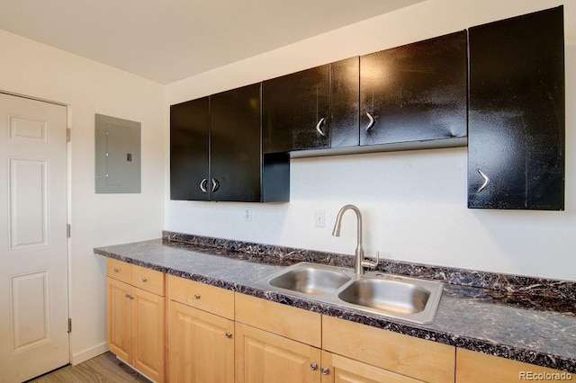 101 Harvard Ln, Buena Vista, CO 81211 - kitchen with electric panel, a sink, light brown cabinets, dark countertops, and light wood finished floors