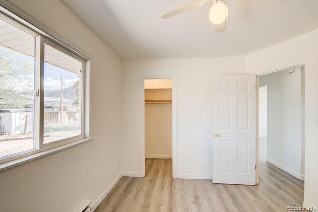 101 Harvard Ln, Buena Vista, CO 81211 - unfurnished bedroom with multiple windows, light wood-style flooring, a walk in closet, and baseboards