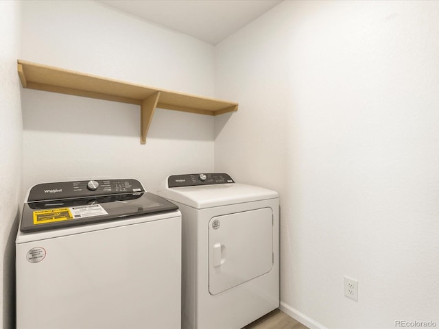 washroom with washing machine and dryer and light hardwood / wood-style flooring