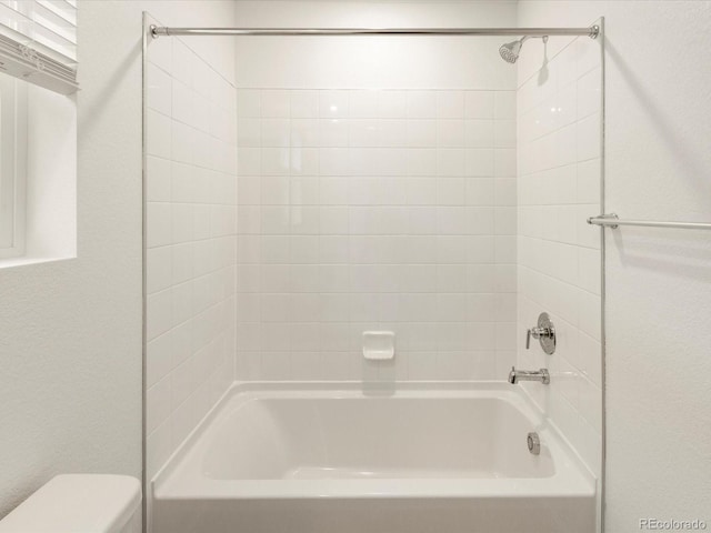 bathroom with tub / shower combination and toilet