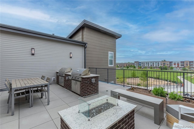 view of patio / terrace featuring a fire pit, an outdoor kitchen, and area for grilling