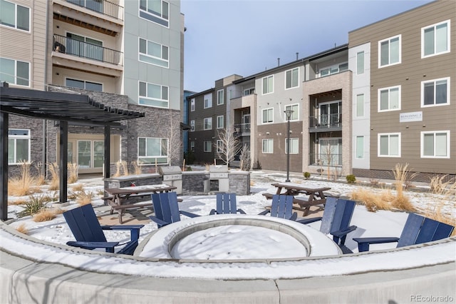 view of home's community with a fire pit and a pergola