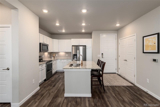 kitchen featuring sink, white cabinetry, appliances with stainless steel finishes, and an island with sink