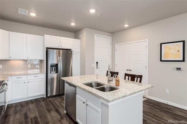 kitchen featuring sink, white cabinetry, a kitchen island with sink, and appliances with stainless steel finishes