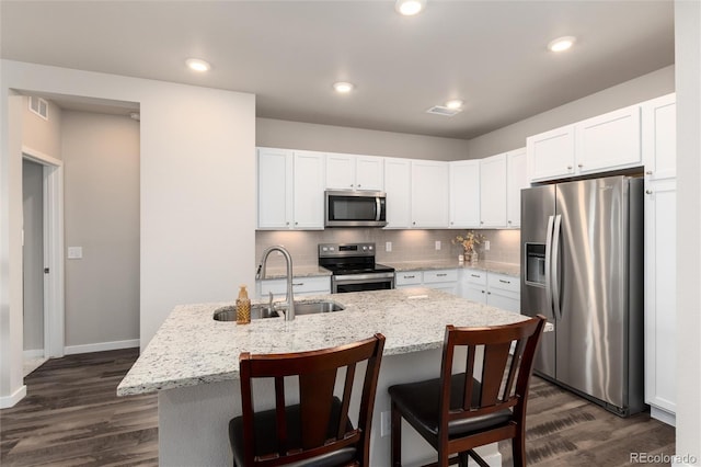 kitchen with sink, white cabinetry, appliances with stainless steel finishes, and a kitchen island with sink