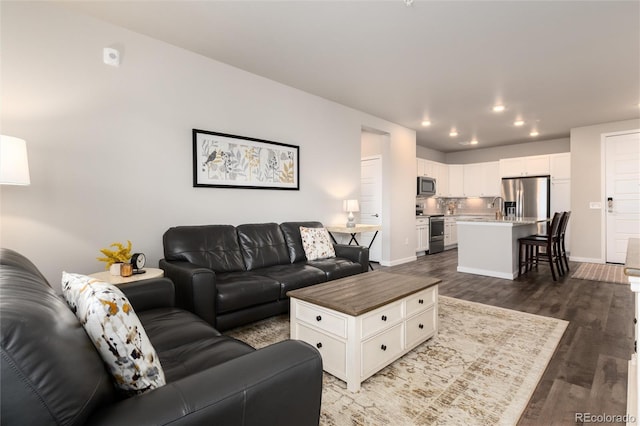 living room featuring sink and dark hardwood / wood-style floors