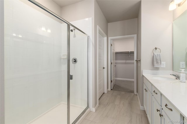 bathroom with a shower with door and vanity