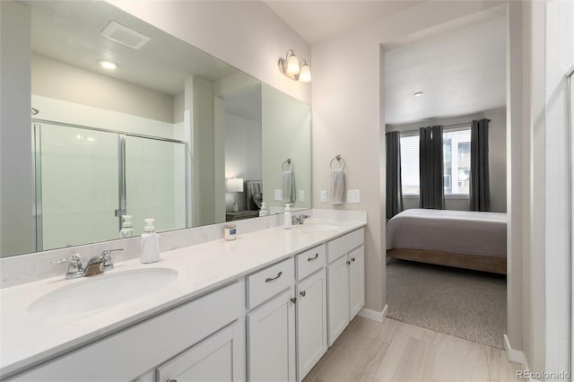 bathroom featuring a shower with shower door and vanity