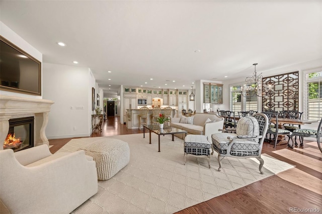 344 Saint Paul St, Denver, CO 80206 - living room featuring light wood-style flooring, a glass covered fireplace, recessed lighting, and a chandelier