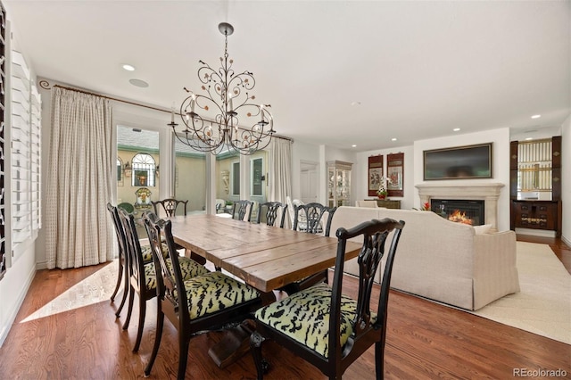 344 Saint Paul St, Denver, CO 80206 - dining room featuring a chandelier, wood finished floors, a glass covered fireplace, and recessed lighting