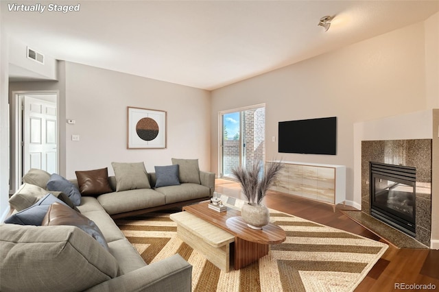 875 E 78th Ave Unit 9-2, Denver, CO 80229 - living room with baseboards, a tiled fireplace, visible vents, and wood finished floors