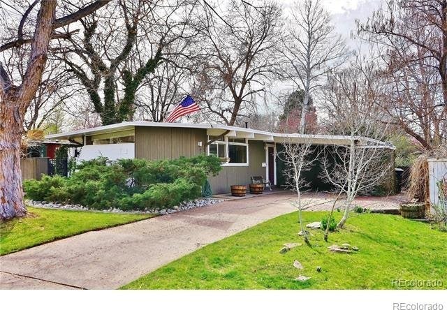 ranch-style home featuring a front lawn and a carport