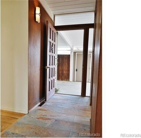 hall featuring beam ceiling and light hardwood / wood-style flooring