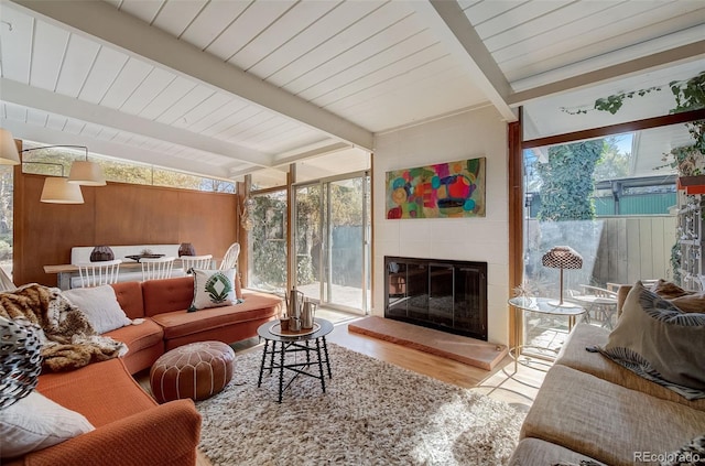 sunroom with beamed ceiling and a fireplace