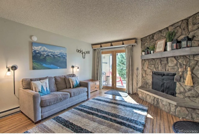 170 Gcr 838 Unit 6, Fraser, CO 80442 - living room featuring wood finished floors, a textured ceiling, a baseboard heating unit, and a fireplace