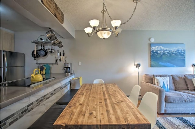 170 Gcr 838 Unit 6, Fraser, CO 80442 - dining area featuring a chandelier, a textured ceiling, and wood finished floors