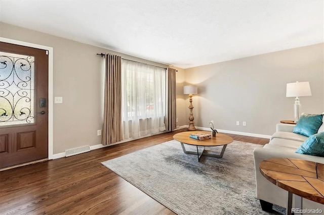 living area featuring wood finished floors, visible vents, and baseboards