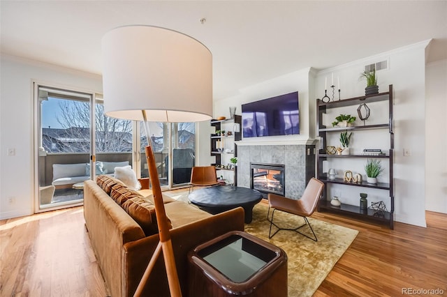 111 S Monroe St Unit B203, Denver, CO 80209 - living area featuring crown molding, wood finished floors, and a tile fireplace