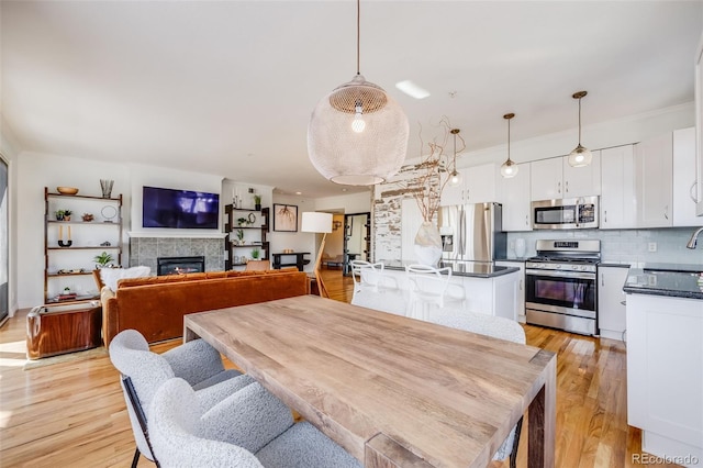 111 S Monroe St Unit B203, Denver, CO 80209 - dining area with light wood-type flooring, a fireplace, and ornamental molding