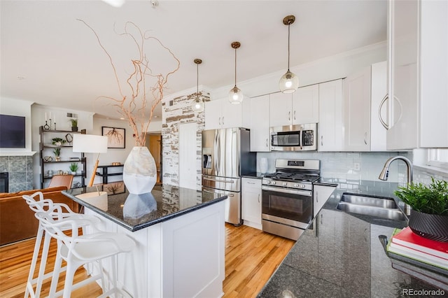 111 S Monroe St Unit B203, Denver, CO 80209 - kitchen with stainless steel appliances, decorative backsplash, white cabinetry, a kitchen bar, and a kitchen island