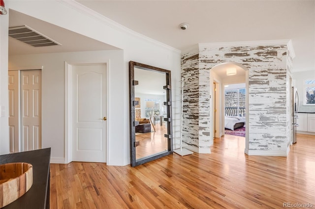 111 S Monroe St Unit B203, Denver, CO 80209 - spare room featuring arched walkways, crown molding, and light wood-type flooring