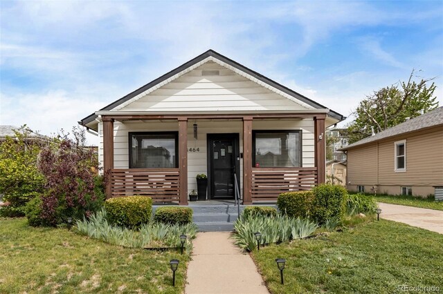 3464 S Downing St, Englewood, CO 80113 - shotgun-style home featuring covered porch and a front yard