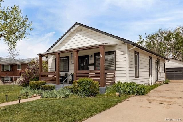3464 S Downing St, Englewood, CO 80113 - view of front of home with a porch, a front lawn, and a garage
