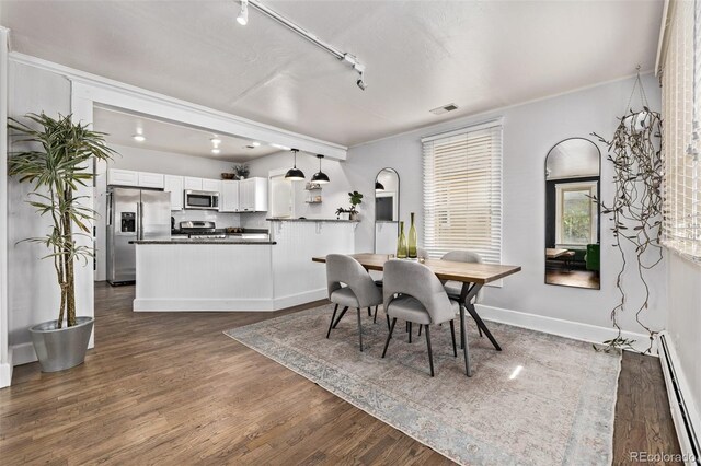 3464 S Downing St, Englewood, CO 80113 - dining space featuring baseboard heating, dark wood-style floors, rail lighting, and ornamental molding