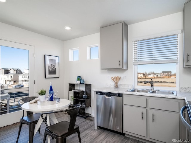 kitchen with gray cabinets, sink, stainless steel dishwasher, and hardwood / wood-style flooring