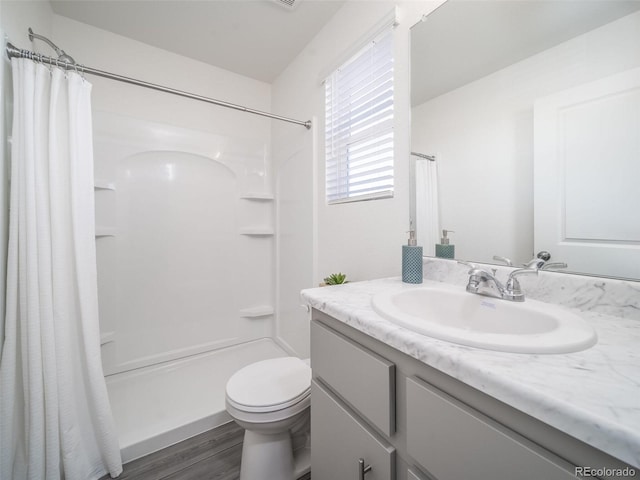 bathroom with curtained shower, toilet, vanity, and hardwood / wood-style flooring