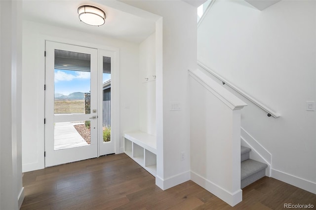 entryway with baseboards, wood finished floors, and stairs