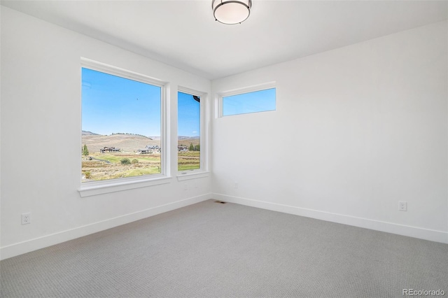 empty room featuring baseboards and carpet floors