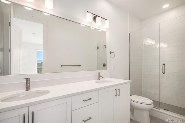 bathroom with a sink, toilet, double vanity, and a shower stall