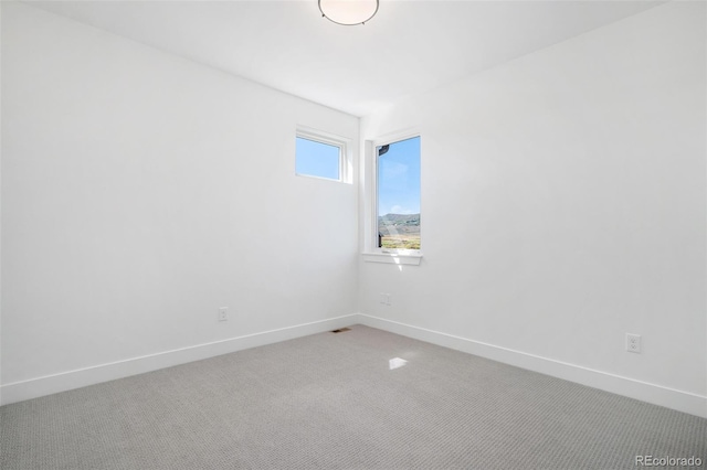 empty room with light carpet, visible vents, and baseboards