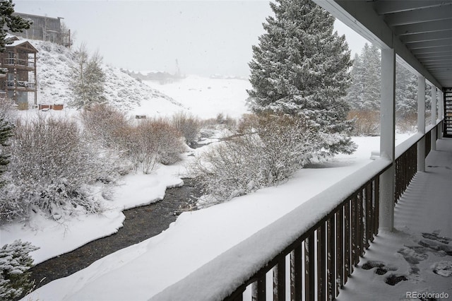 view of snow covered back of property