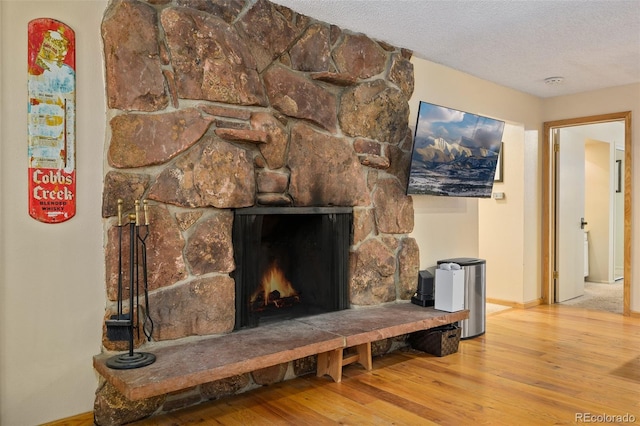 room details featuring a fireplace, a textured ceiling, and hardwood / wood-style flooring