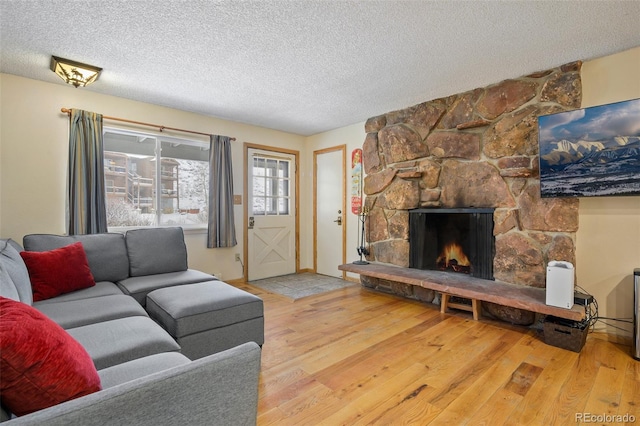 living room with a fireplace, wood-type flooring, and a textured ceiling