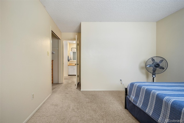 bedroom with light colored carpet and a textured ceiling