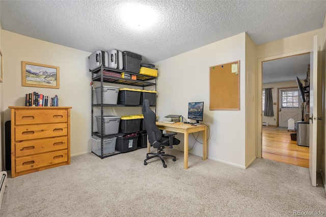 office area with light colored carpet, a textured ceiling, and a baseboard radiator